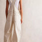 Back view of cream wide-leg denim overalls with cross-back straps