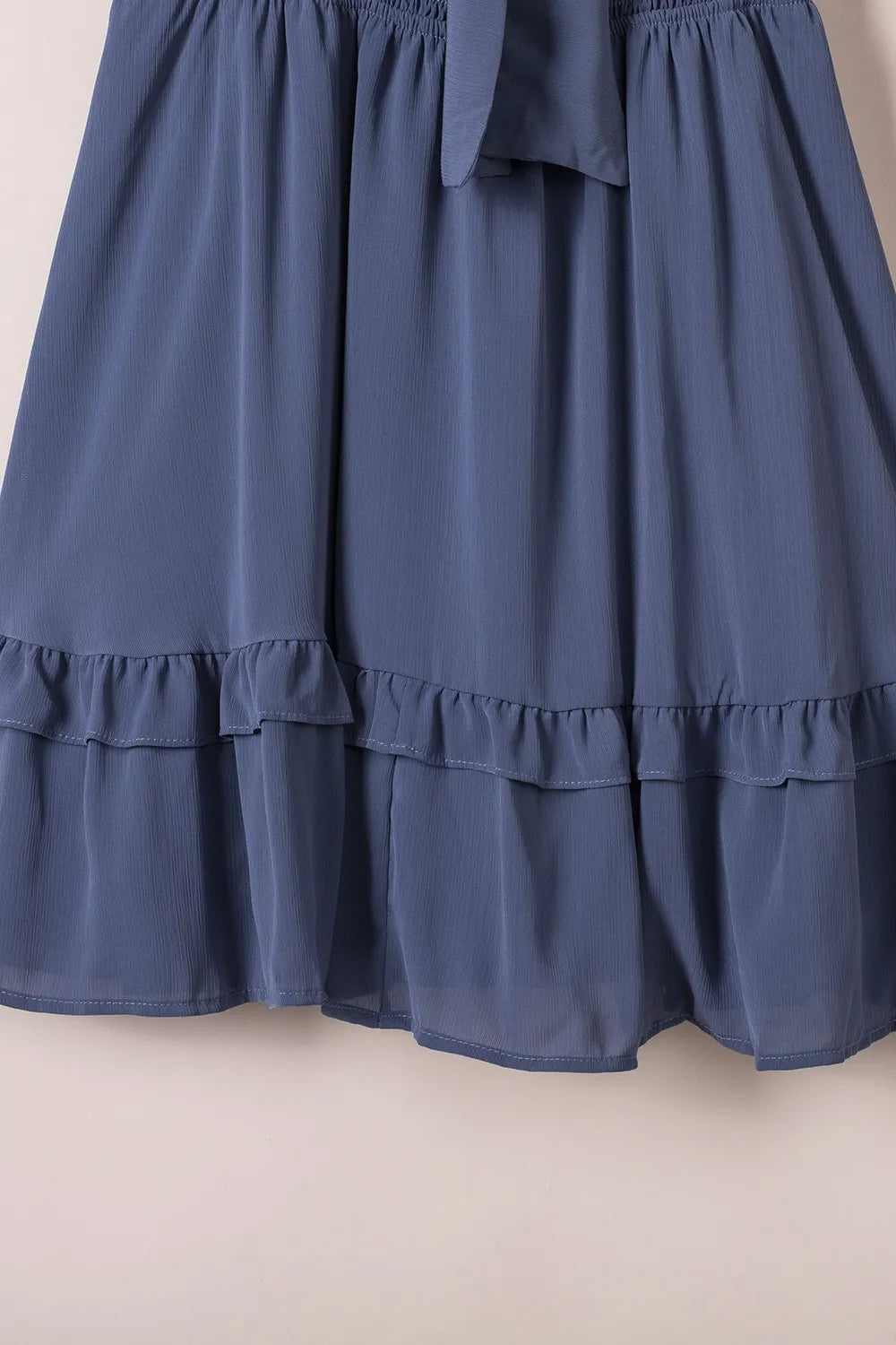 Tie-front mini dress in soft blue with tiered ruffle hem and elastic waistband