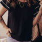 Black short-sleeved textured blouse with contrast trim, dual ruffles, white sleeve accents, and side buttons