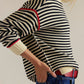 Striped round neck long sleeve sweater in black and white with red cuffs