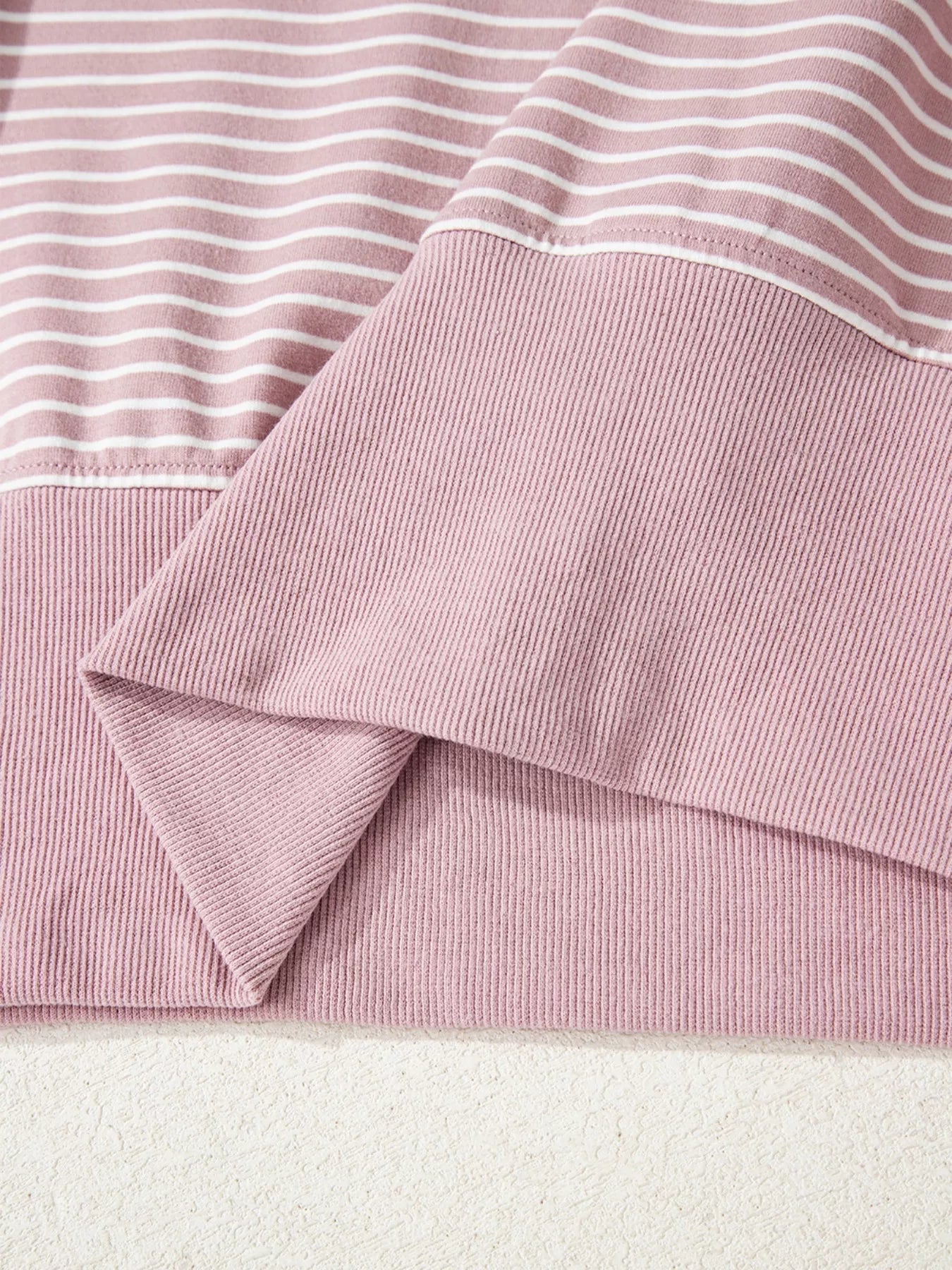 Dusty pink striped ribbed knit hoodie with thumbholes, side slits, drop shoulders, loose fit, folded cuffs, and hood