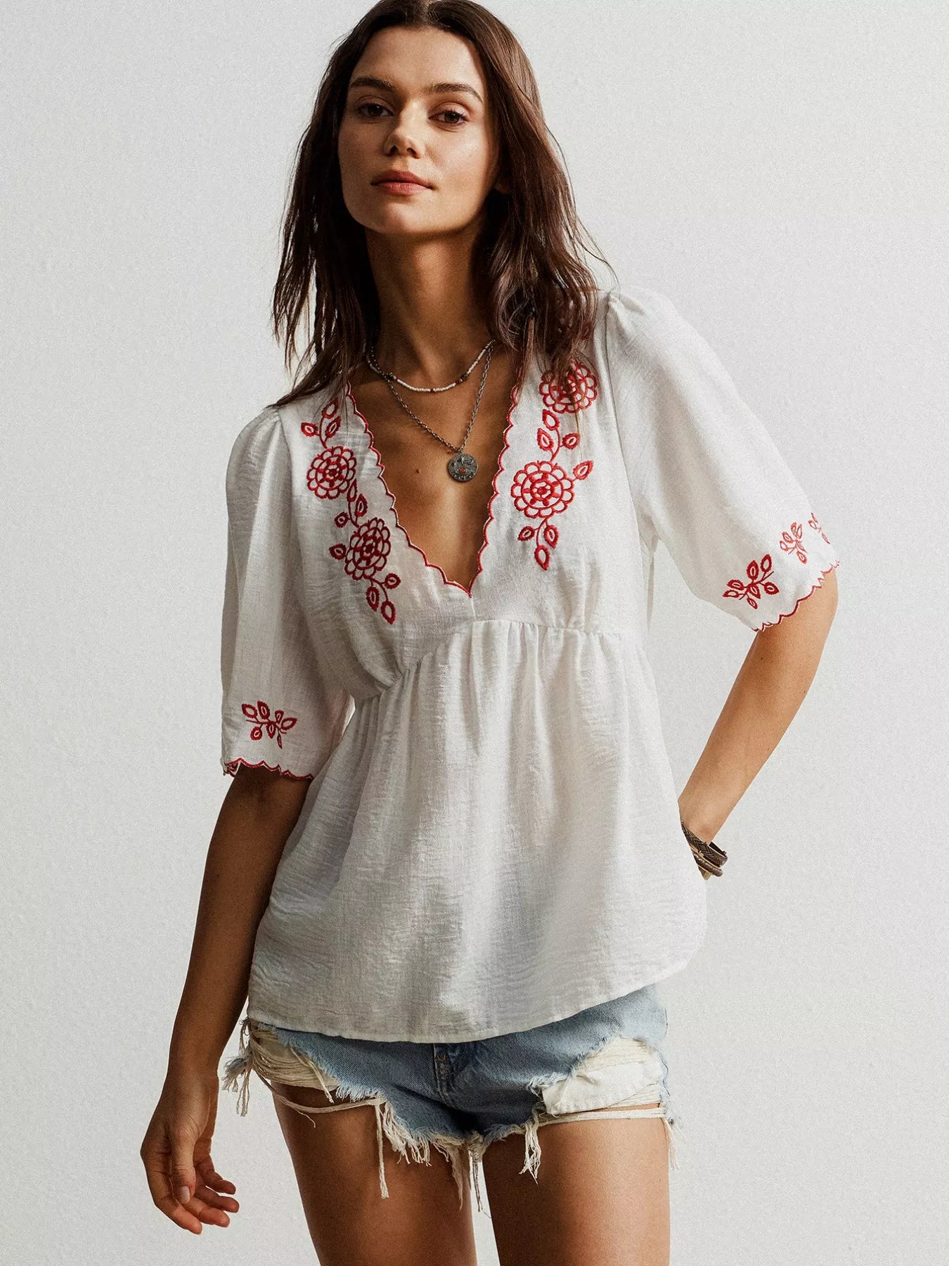 White embroidered floral V-neck blouse with red thread detailing