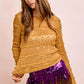 Mustard yellow textured sweater with ruffled sleeves and sequined pants