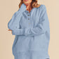 Woman wearing a light blue hoodie  over a black outfit on a beige background