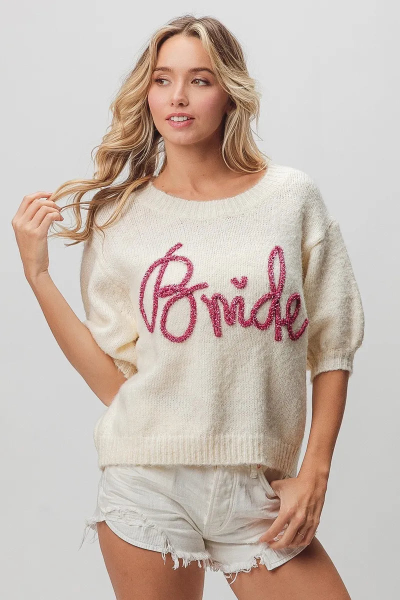 Cream-colored knit bride sweater with pink glitter text