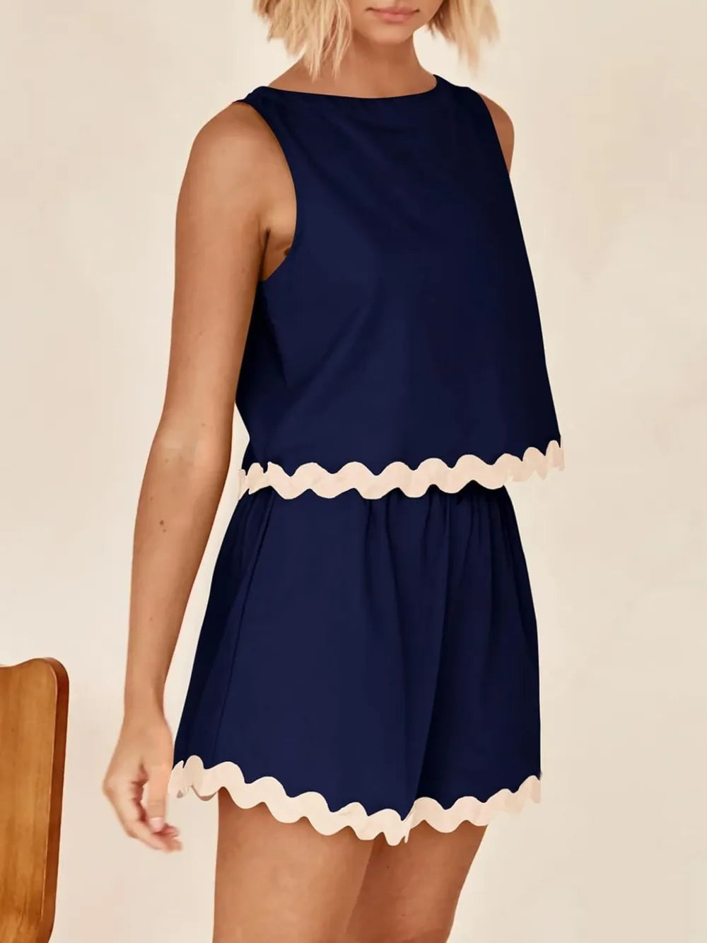 Navy blue Daverri sleeveless romper with cream scalloped trim