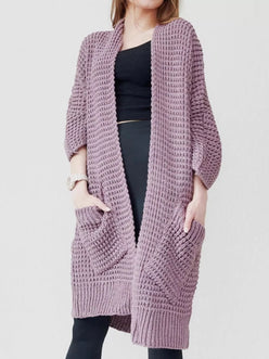 Woman wearing a soft lavender chunky knit open-front cardigan with a waffle texture and large side pockets, paired with jeans.
