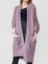 Woman wearing a soft lavender chunky knit open-front cardigan with a waffle texture and large side pockets, paired with jeans.