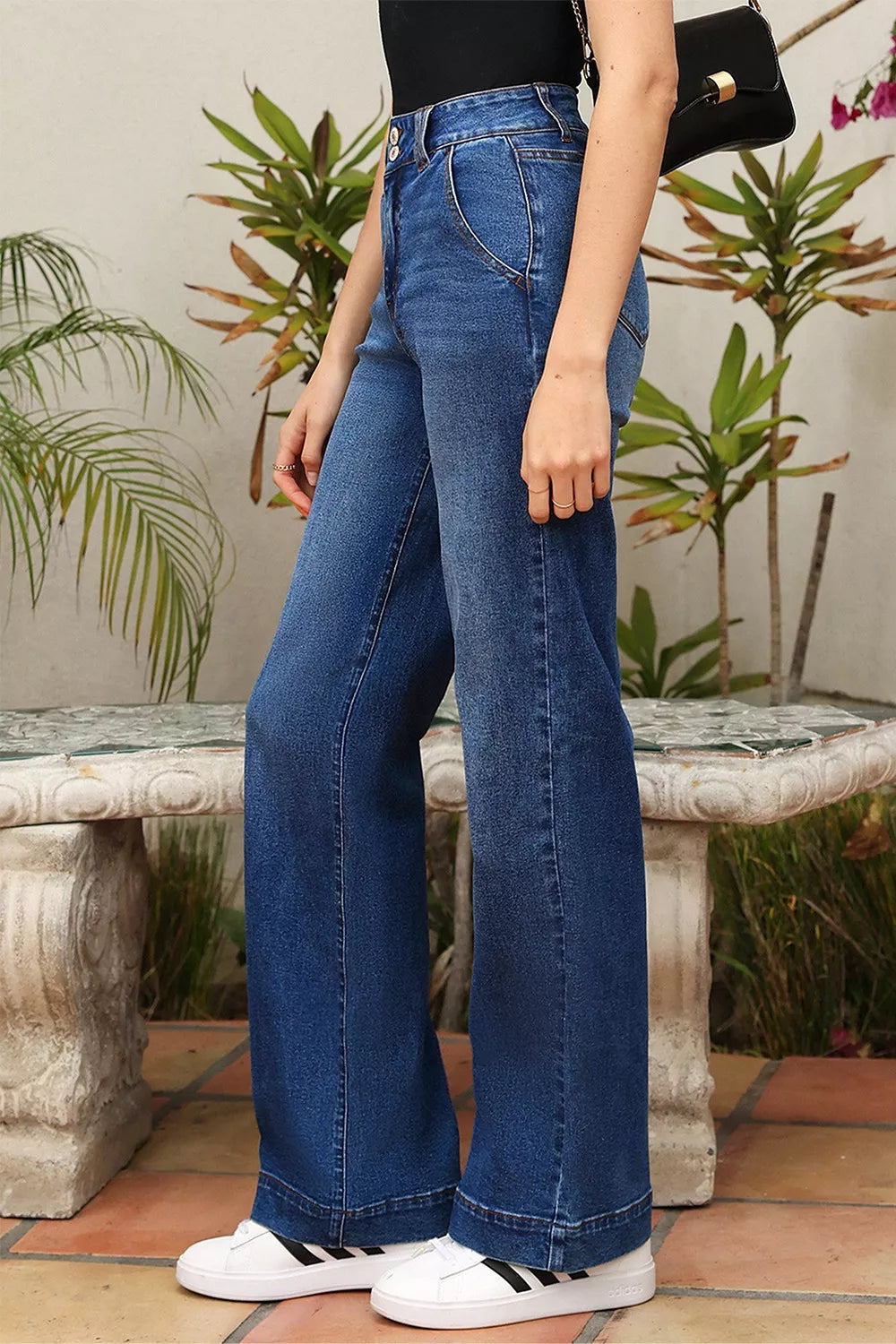 High-waisted blue denim flare pants with five-pocket design and rolled cuffs