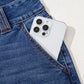 White iPhone with triple-lens camera in Daverri jeans pocket