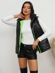 Black zip-up quilted puffer vest with green accents and hood, medium