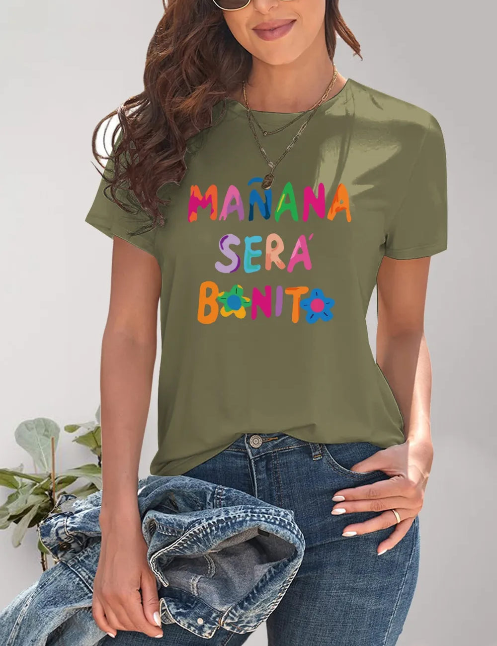Olive green short-sleeve t-shirt with Manana Sera Bonito graphic and distressed denim jeans