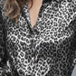 Sleek black and silver leopard-print button-up long sleeve blouse with satin sheen