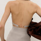 Back view of Backless Turtleneck Sweater Tank in light gray ribbed knit with gold horsebit buckle