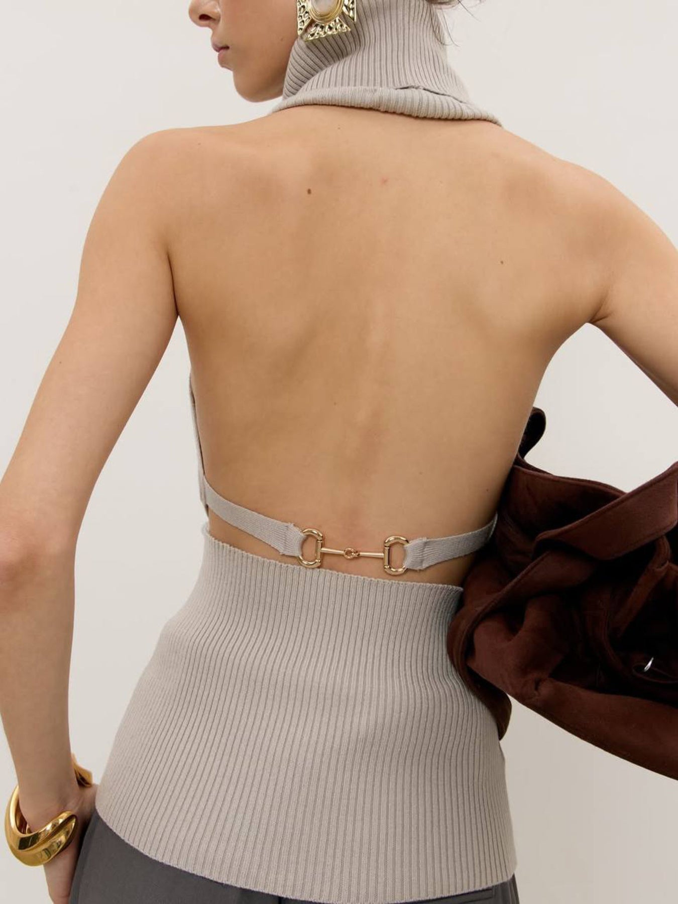 Back view of Backless Turtleneck Sweater Tank in light gray ribbed knit with gold horsebit buckle