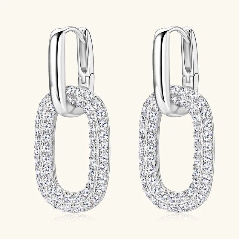 Pair of silver hoop earrings with clear gemstones on a white background