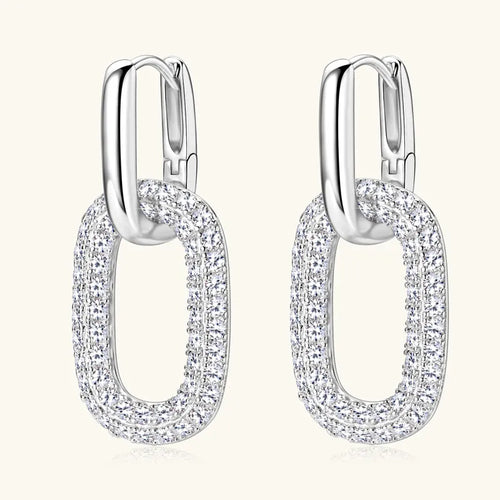 Pair of silver hoop earrings with clear gemstones on a white background