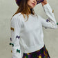 White SO ME Mardi Gras sweater with purple, gold, green sequined bows