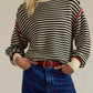 Striped round neck long sleeve sweater in black and white with red trim