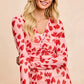 Pink long-sleeved BiBi button-down shirt with red heart print and gold buttons