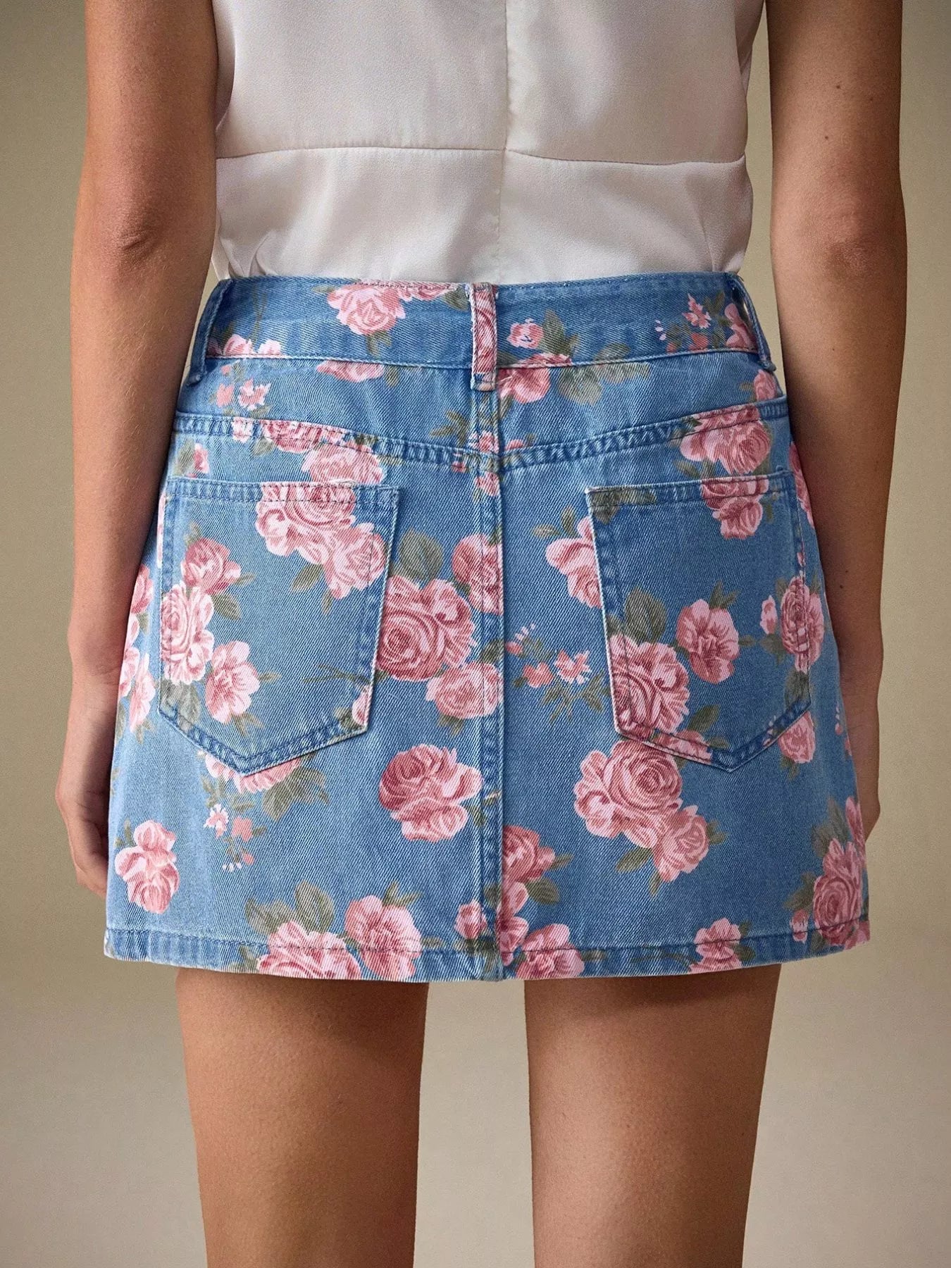 Floral print denim mini skirt with pink rose pattern on light blue fabric