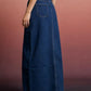 Raw hem maxi denim skirt back view with dark blue denim pocket and frayed hem
