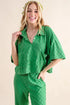 Green checkered linen jumpsuit with short sleeves and button front