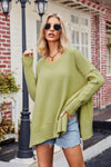 Olive green oversized V-neck knit sweater with ribbed cuffs and hem