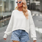 White dropped shoulder knit top with ribbed cuffs, paired with distressed denim shorts