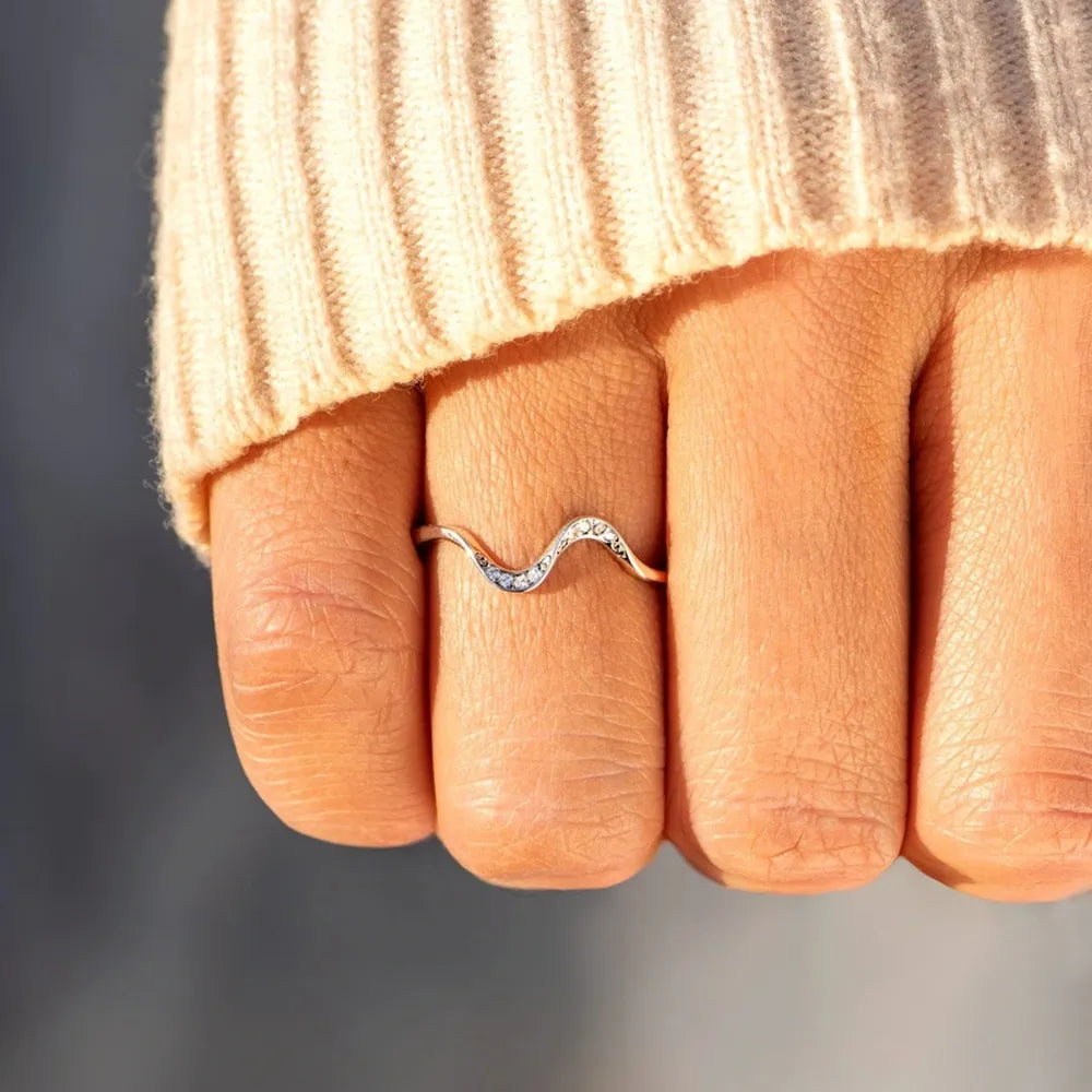 Hand wearing a sterling silver wavy ring