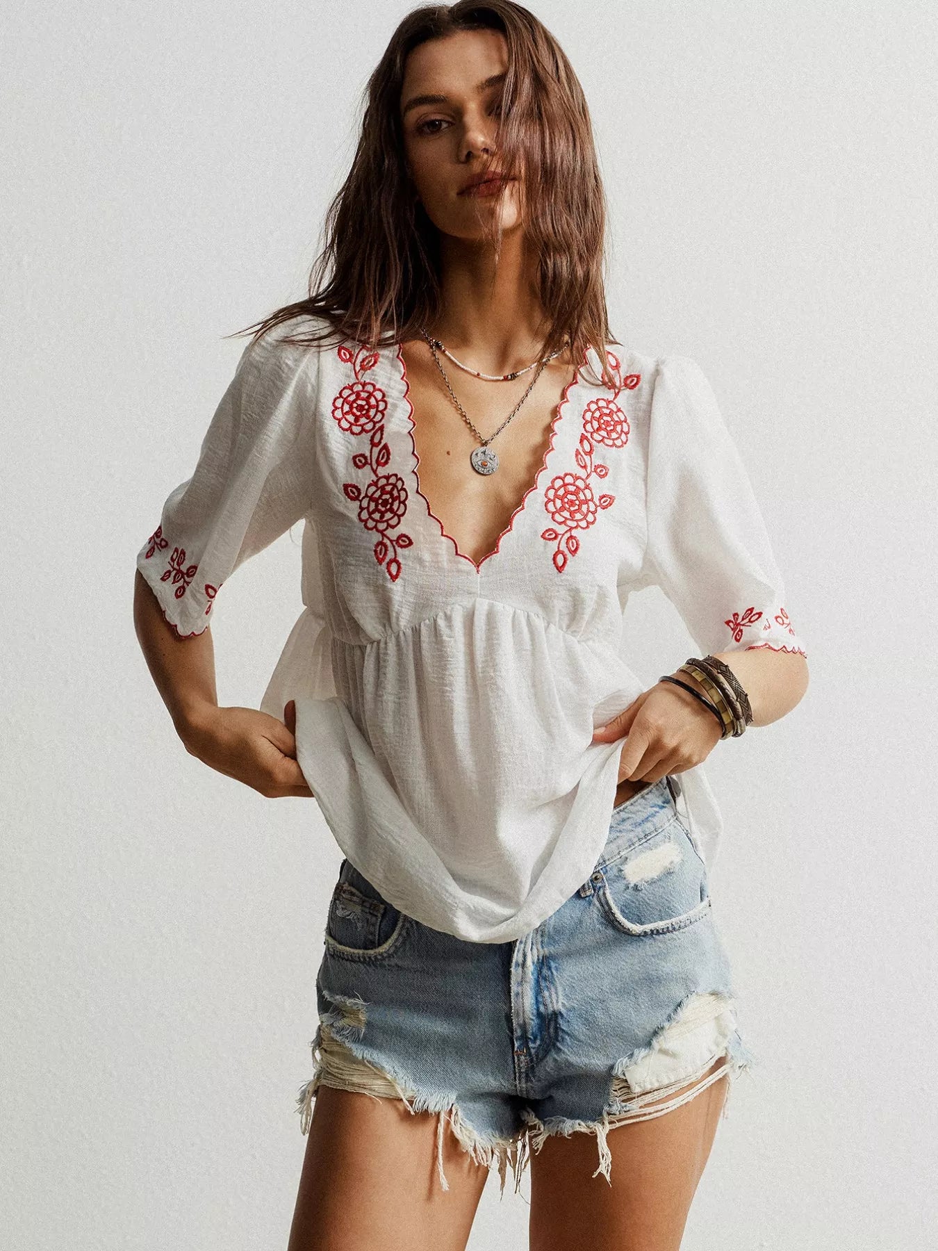 Embroidered floral V-neck blouse in white with red floral accents