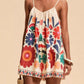 Vibrant off-white floral spaghetti strap romper with colorful embroidered blossoms