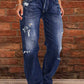 Distressed loose fit blue denim jeans with frayed hems and thigh rips