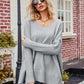 Light gray ribbed V-neck sweater with bell sleeves and slit seams