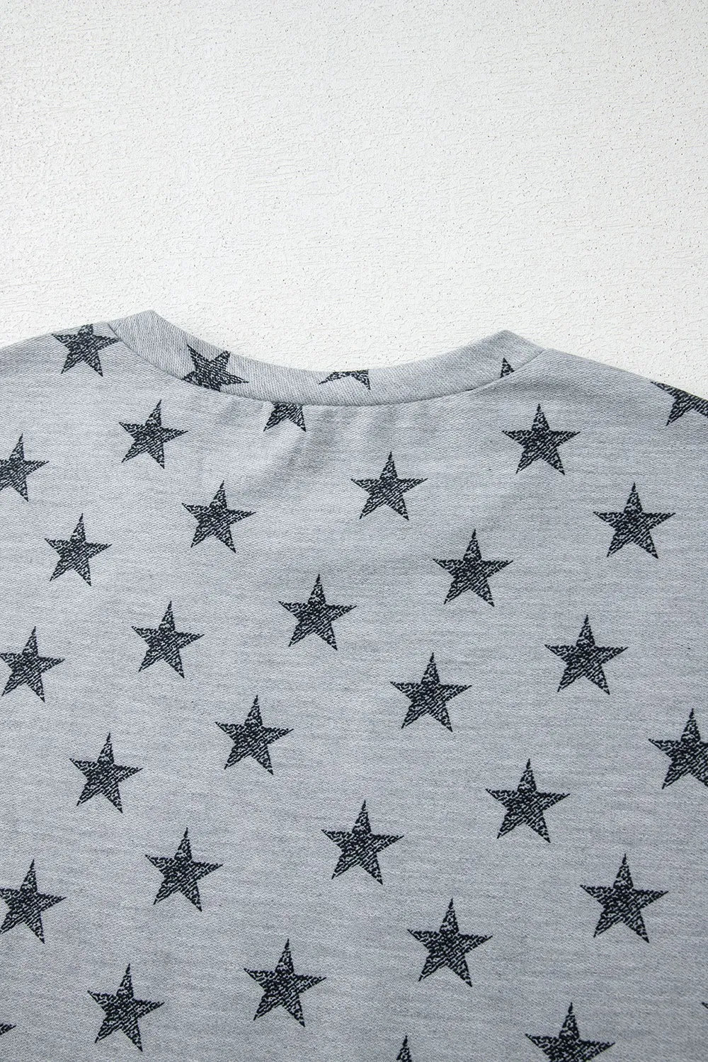 Gray star-patterned cotton t-shirt with black embroidered stars and ruffled sleeves
