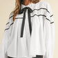 White blouse with black wavy stripes and ribbon bowtie neck