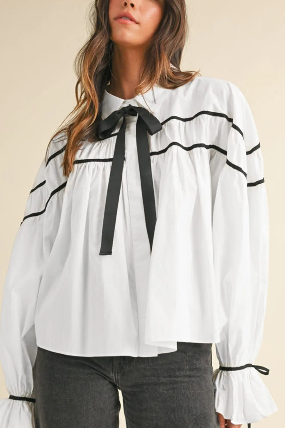 White blouse with black wavy stripes and ribbon bowtie neck