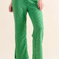Green quilted linen pants with pockets, checkerboard pattern, and woven sandals