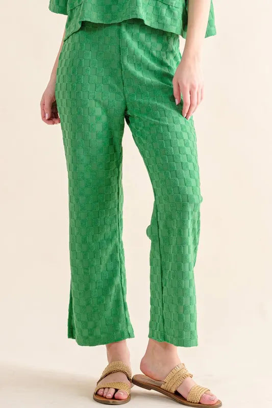 Green quilted linen pants with pockets, checkerboard pattern, and woven sandals