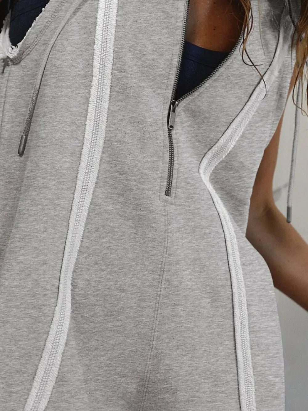 Gray heathered sleeveless half-zipped hooded romper with white stitching