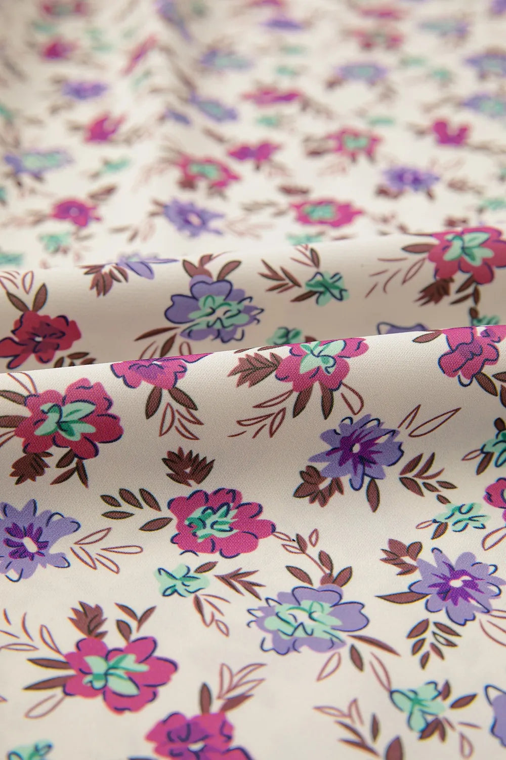 Cream-colored ditsy floral smocked fit flare sundress with pink, purple, teal blossoms