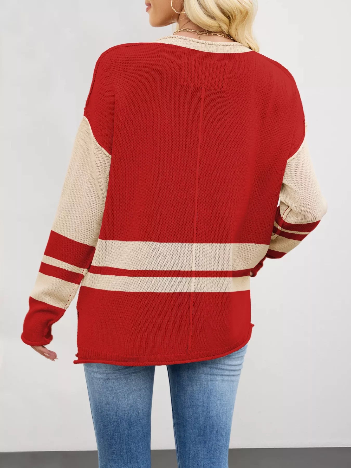 Red and cream color block knit sweater with striped sleeves