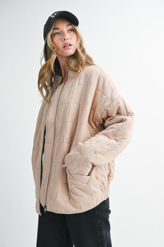 Beige quilted Dixie Jacket with black zipper and ribbed cuffs
