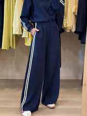 Navy blue track pants with white stripes in casual sportswear set