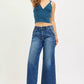 Woman in RISEN high-rise wide-leg jeans with teal cropped knit top