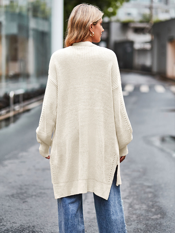 Cream-colored oversized waffle-knit cardigan with textured weave and side slits