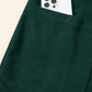 Dark green corduroy pocket with white smartphone in women’s jumpsuit