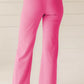 Bright pink high-waisted bootcut pants in smooth tailored fabric