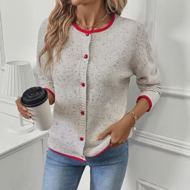 Video of woman wearing speckled button cardigan with red trim
