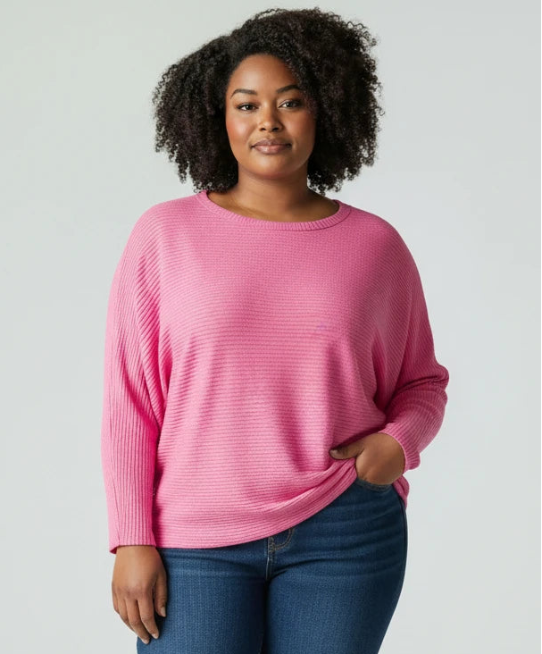 Woman wearing a pink sweater and blue jeans on a white background